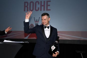 Nicolas Roche in a suit waving at a charity gala